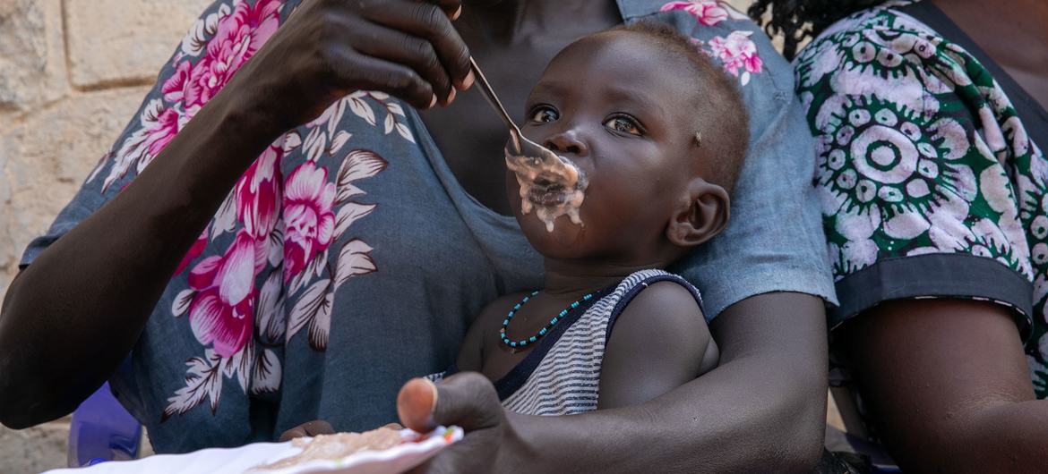 Una mujer alimenta a su hijo en un sitio de nutrición en Sudán del Sur.